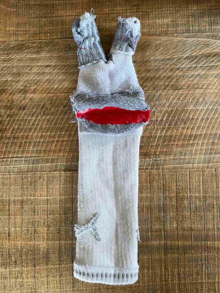 Homemade sock puppet with cardboard mouth and elastic eyes
